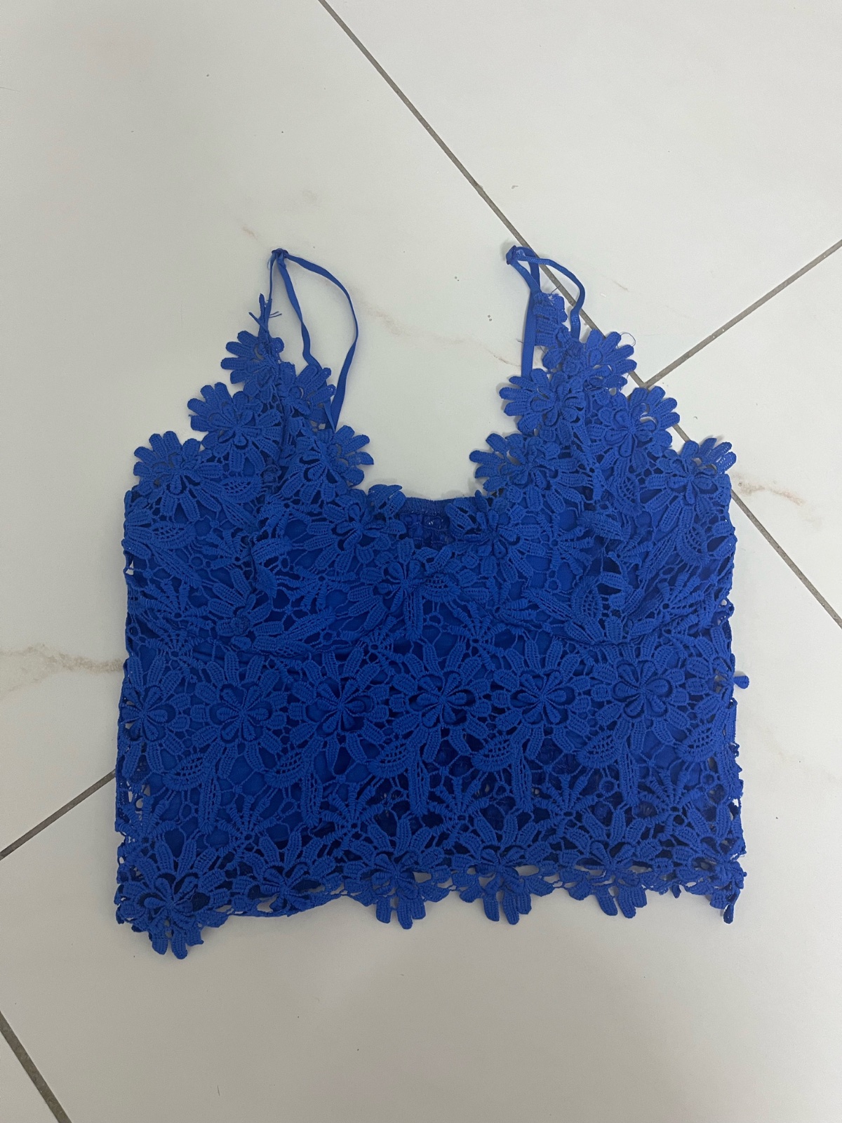 Haut de type caraco en crochet bleu  caractérisé par des motifs floraux