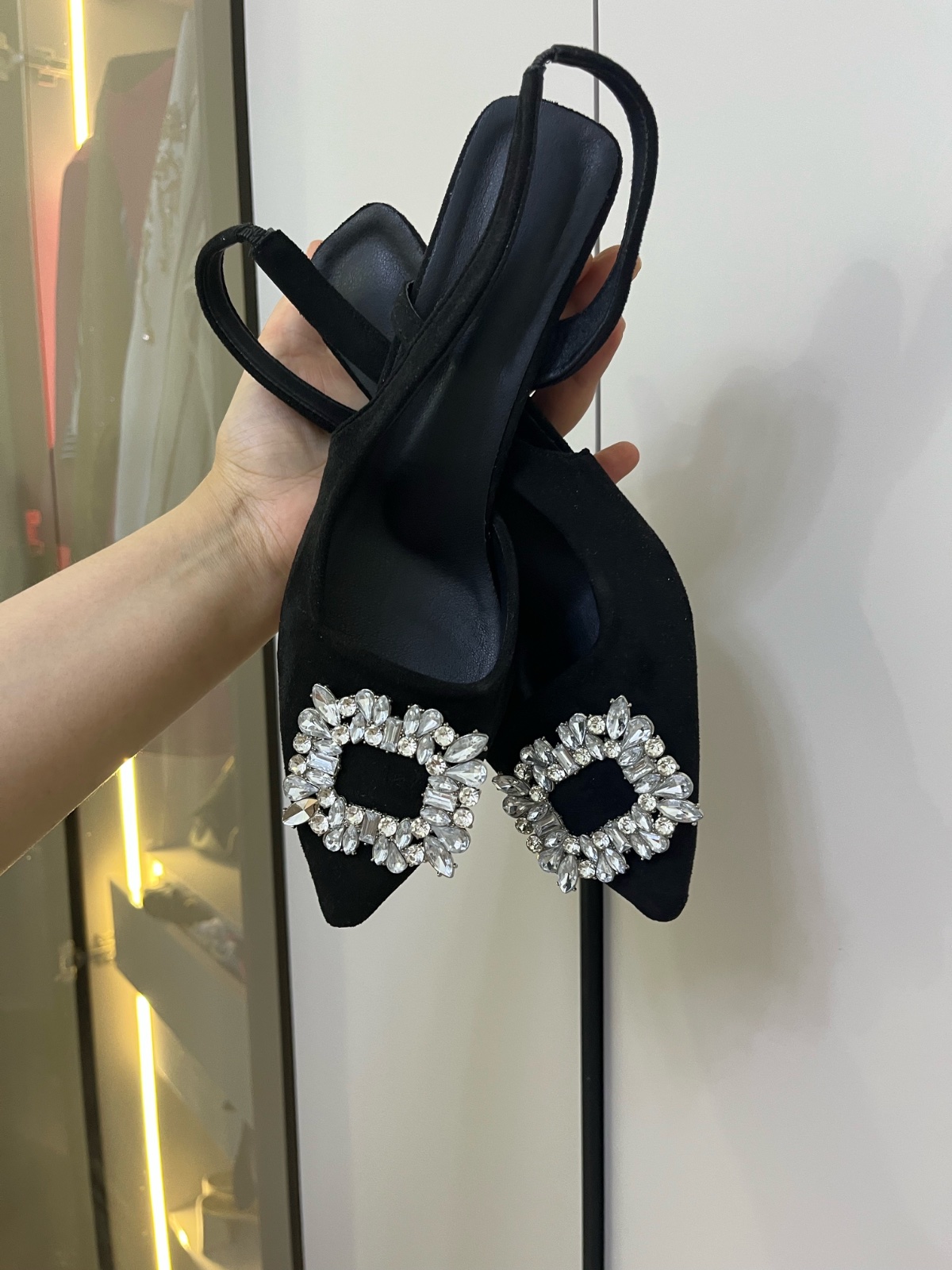 Escarpins slingback noirs, repérés sur Vinted, se distinguent par leur grande boucle carrée ornée de strass brillants