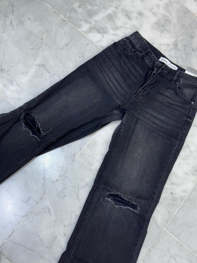 Pantalon jean noir déchirés au niveau des genoux