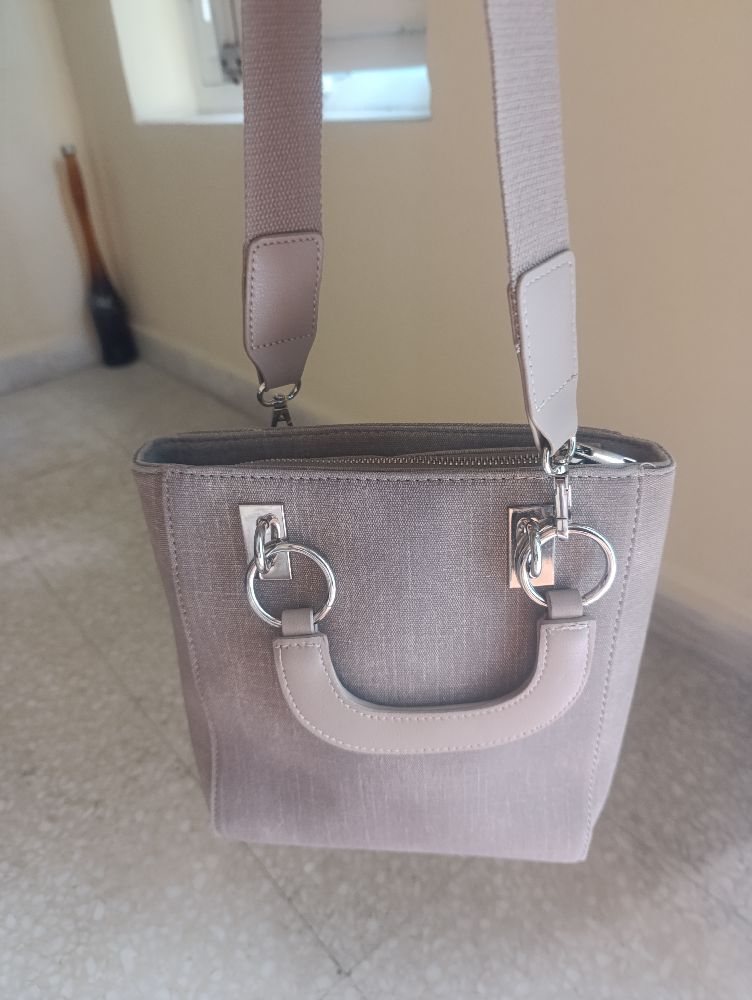 Un sac  à bandouliére de couleur beige en trés bon etat.