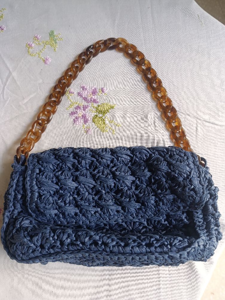 Un mini sac á main bleu marine en crochet avec une chaine mecca 