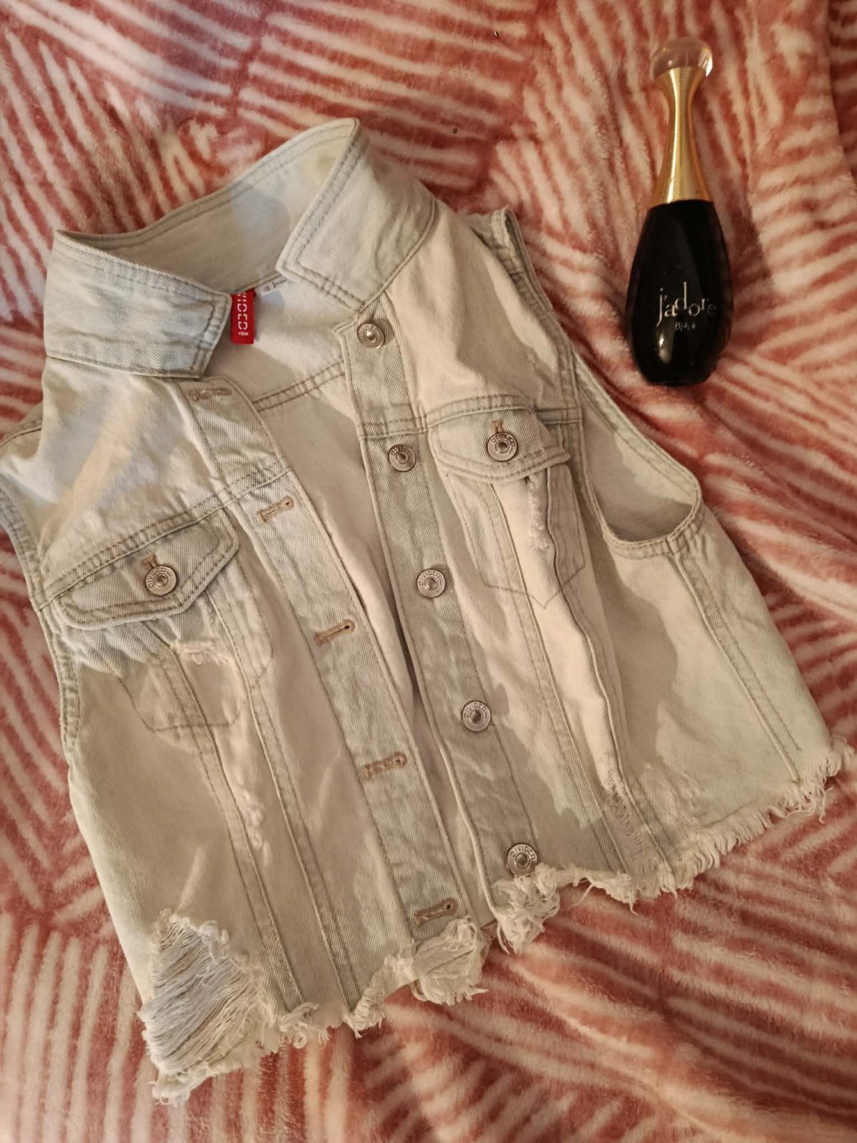Veste est un blouson en jean de la gamme Divided de chez H&M, reconnaissable à son étiquette rouge caractéristique
