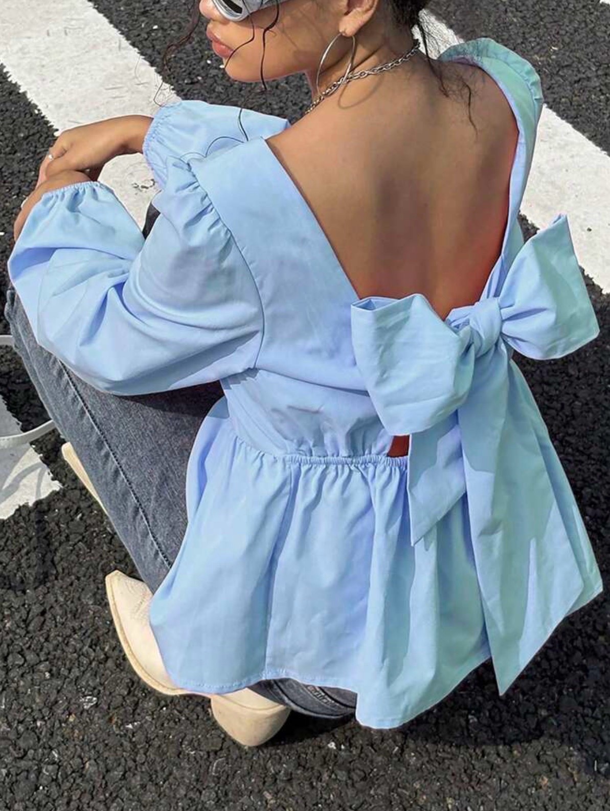 Blouse à ourlet péplum avec un grand nœud au dos et des manches bouffantes, de couleur bleu ciel