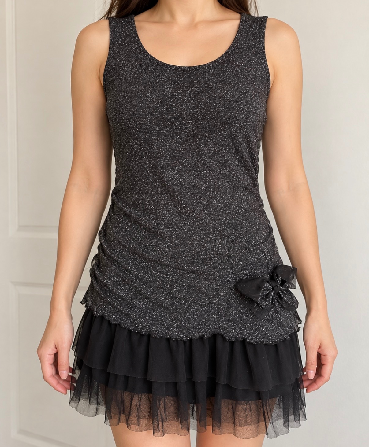 Modèle exact : Robe de fête sans manches pour fille Petit Môme — Modèle noir à paillettes/lurex argenté, nœud à la taille et bas volant en tulle/voile (Marque : Petit Môme | Couleur : Noir argenté brillant | Étiquette dépôt présente