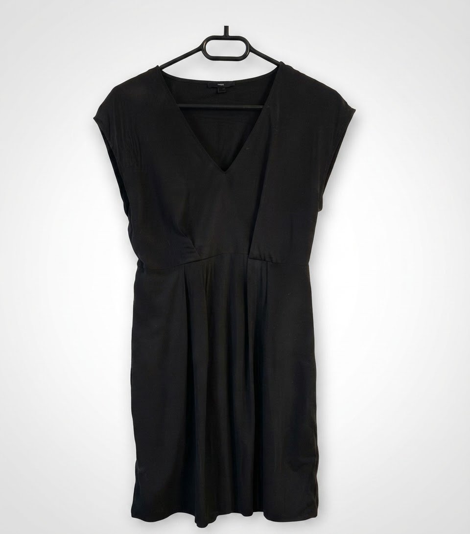 Cette robe noire H&M à manches courtes présente un élégant décolleté en V et une coupe cintrée à la taille avec une jupe fluide.