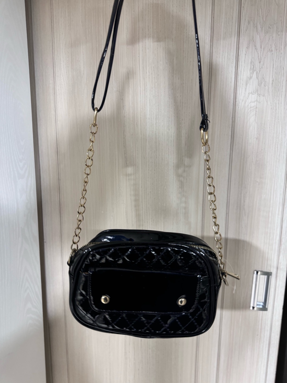 Sac bandoulière noir brillant matelassé avec chaîne dorée