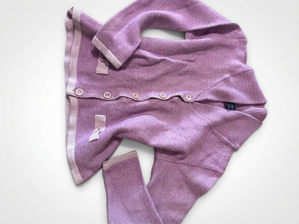 Cardigan rose en maille à boutons possède un col châle, des manches longues et deux poches avant avec des finitions contrastantes.