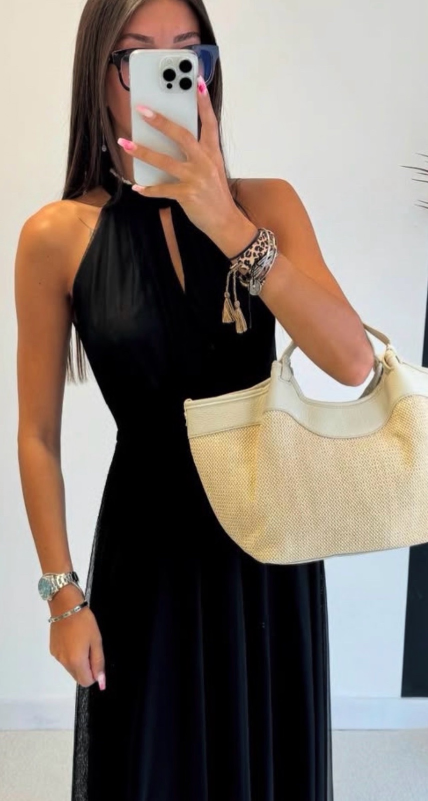 Une robe longue noire avec un col licou et un détail plissé, parfaite pour des soirées