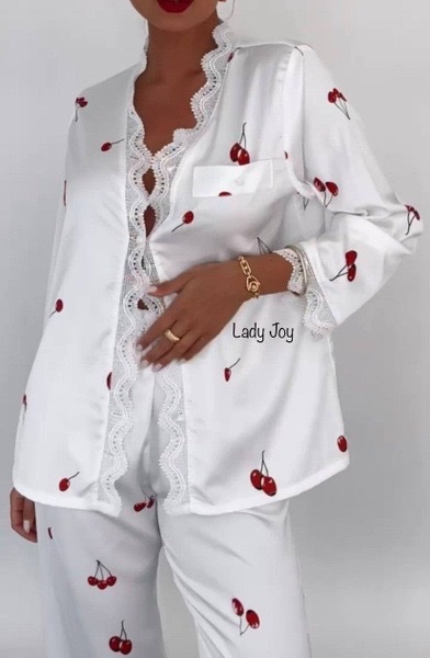 Pyjama femme en satin blanc présente un imprimé cerise et des détails en dentelle importée