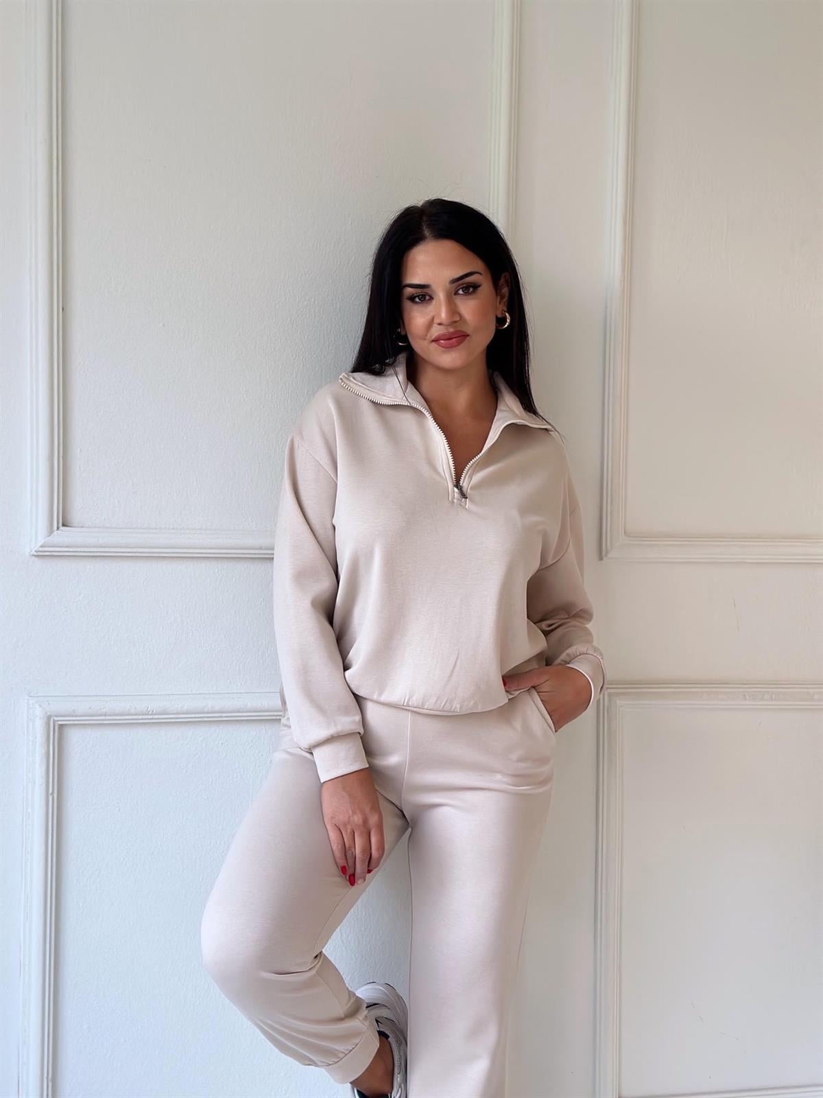 Vêtement est un ensemble de survêtement beige pour femme composé d'un sweat-shirt à col montant et demi-zip ainsi que d'un pantalon assorti à taille élastique et poches latérales, très similaire à la collection Soft Touch Taille S