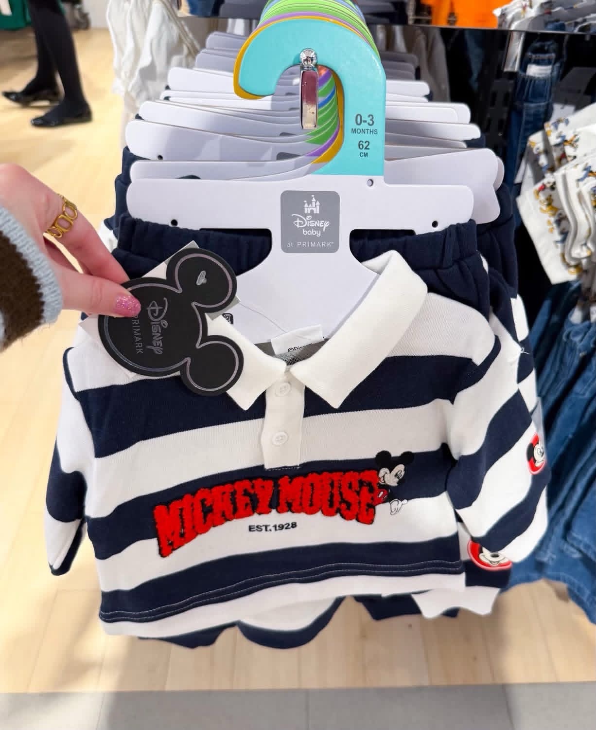Ensemble polo et pantalon rayé Mickey Mouse de la collection Disney Baby chez Primark, avec des rayures bleu marine et blanches ainsi qu'un motif brodé « Mickey Mouse Est. 1928 » sur le devant