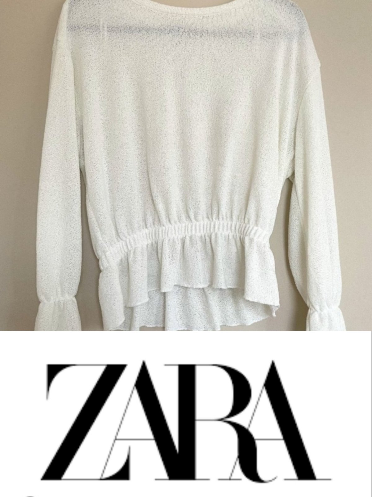 Pull-over blanc de la marque Zara doté d'une taille élastiquée et de poignets volantés