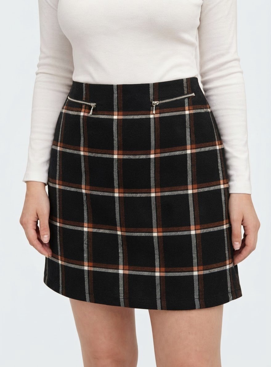 Jupe noire à motif écossais quadrillé de lignes marron et blanches, agrémentée de petites poches zippées décoratives sur le devant
