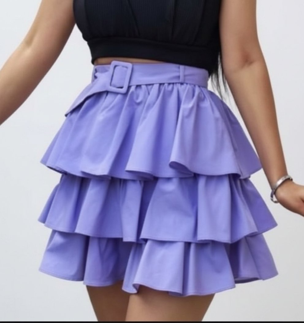 Jupe courte lilas à volants superposés avec ceinture assortie à la taille. Coupe fluide et féminine, parfaite pour un look chic et tendance 💜