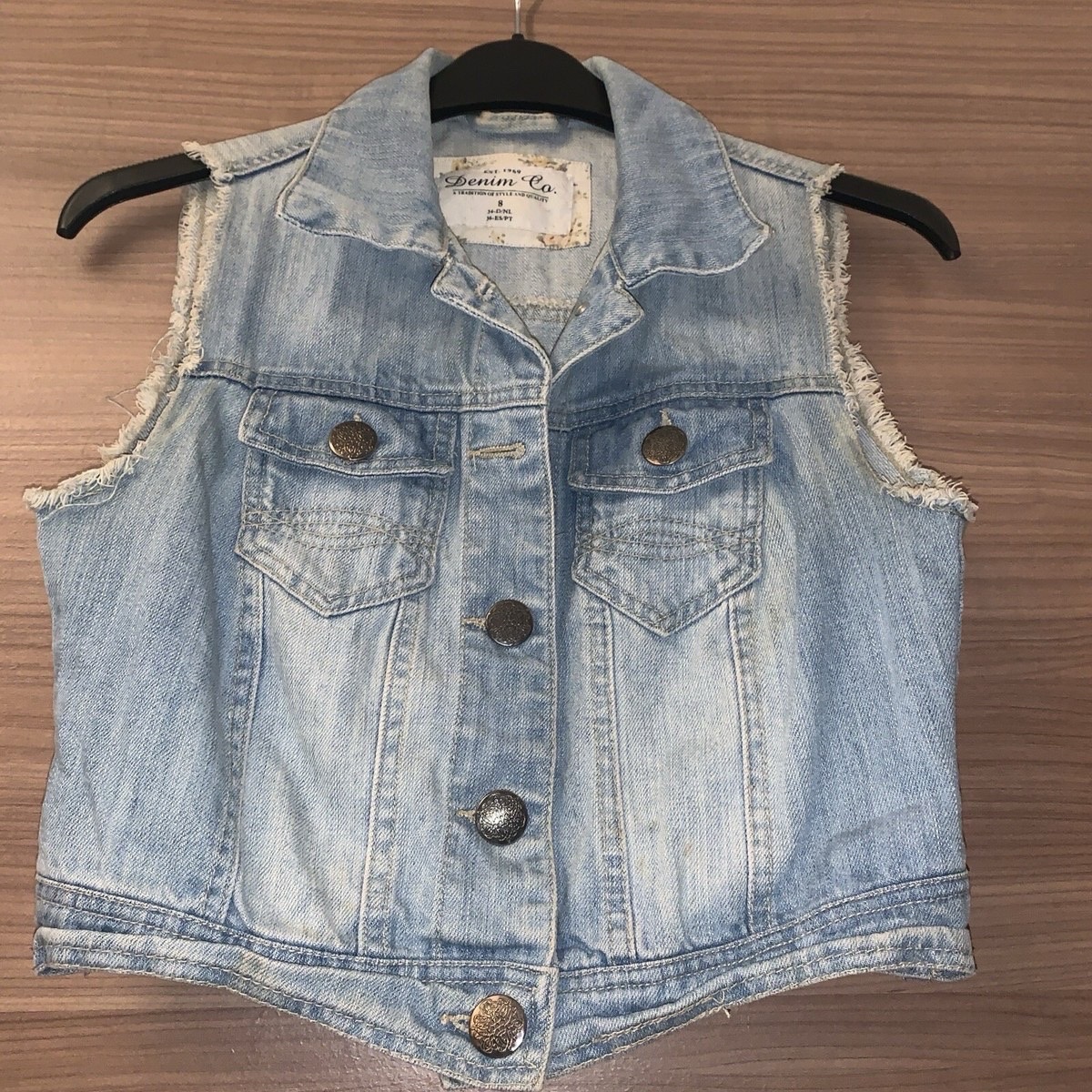 A light wash "Denim Co." denim vest. 