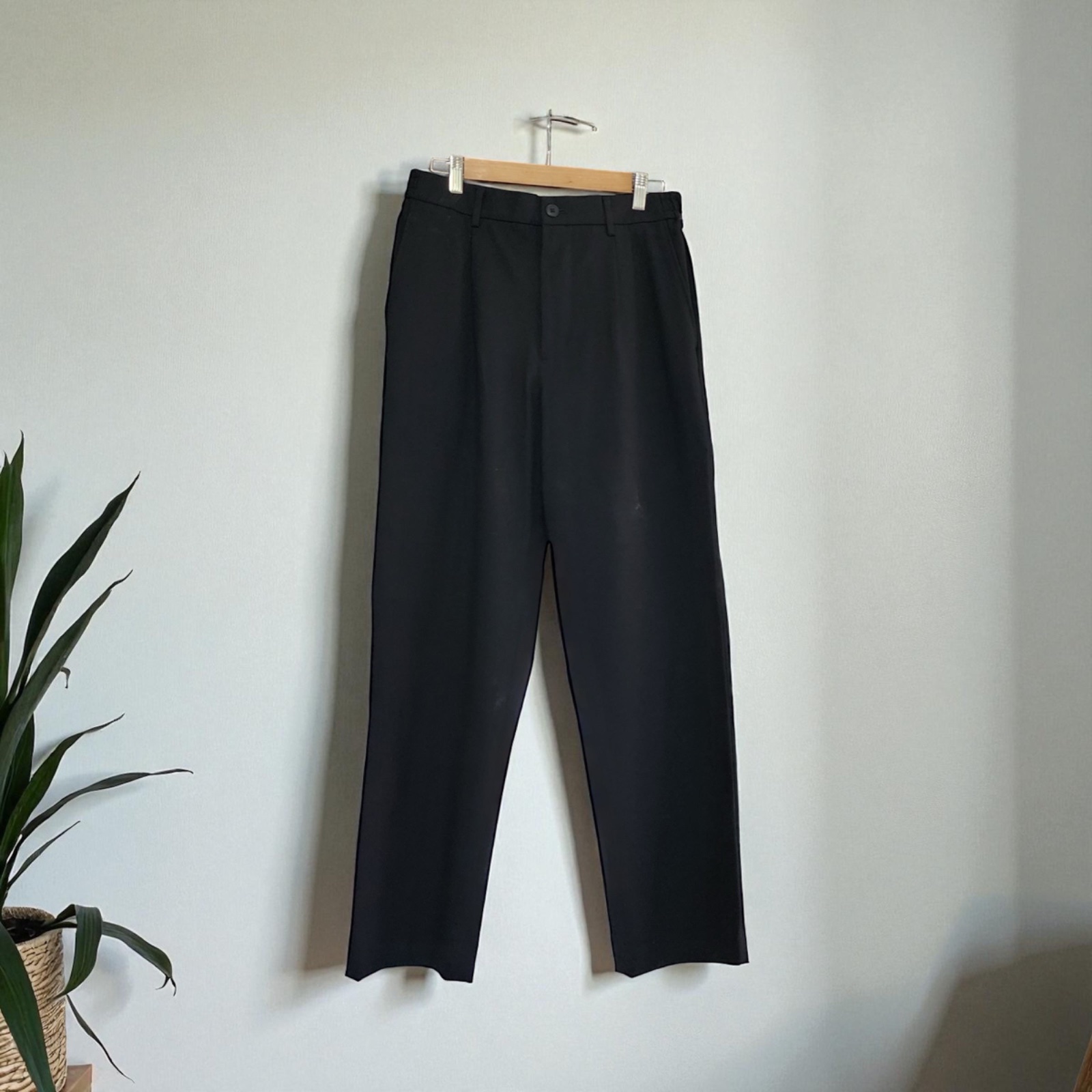 Black high-waisted pleated trousers. 