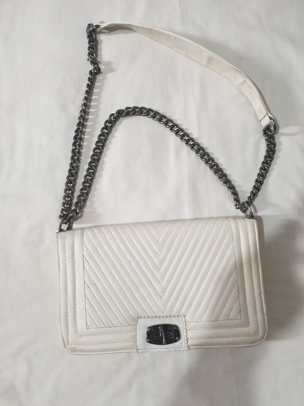 Sac à bandoulière matelassé blanc avec une chaîne et une bandoulière en similicuir