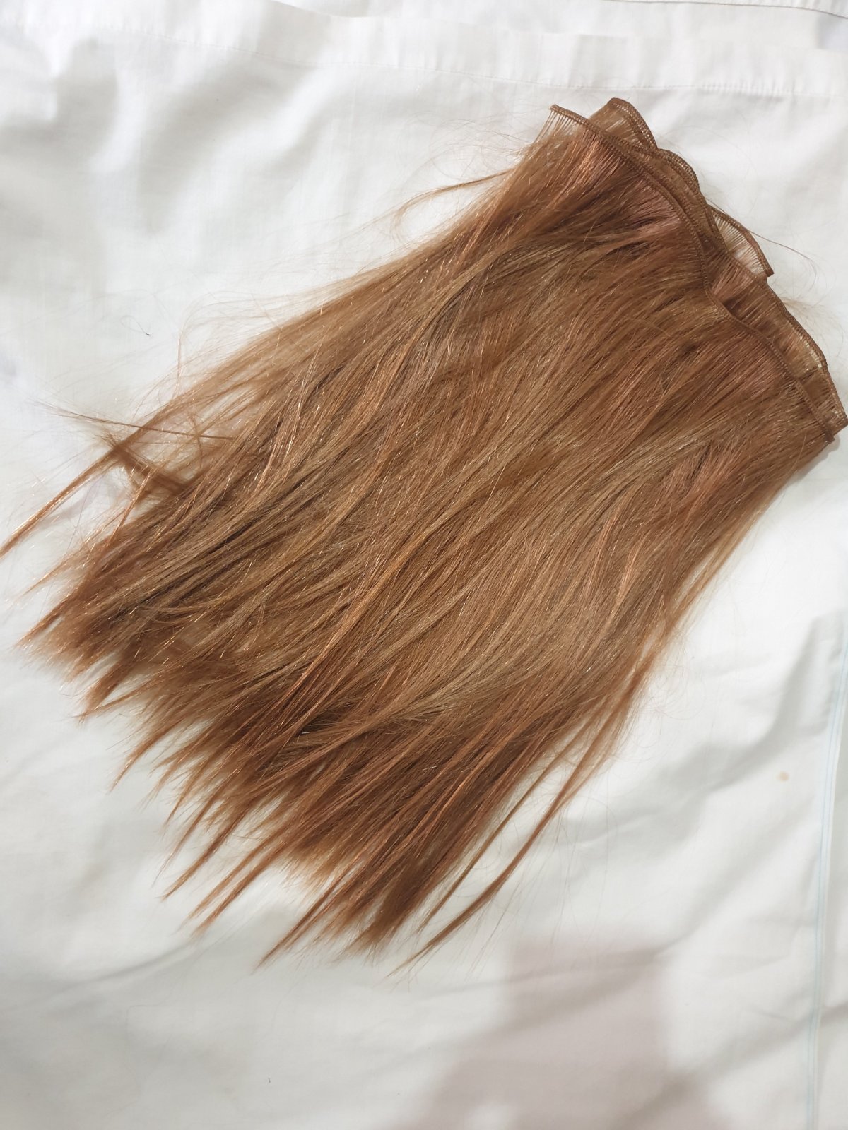 Extensions de cheveux de couleur châtain clair, conçues pour ajouter du volume ou de la longueur à une chevelure