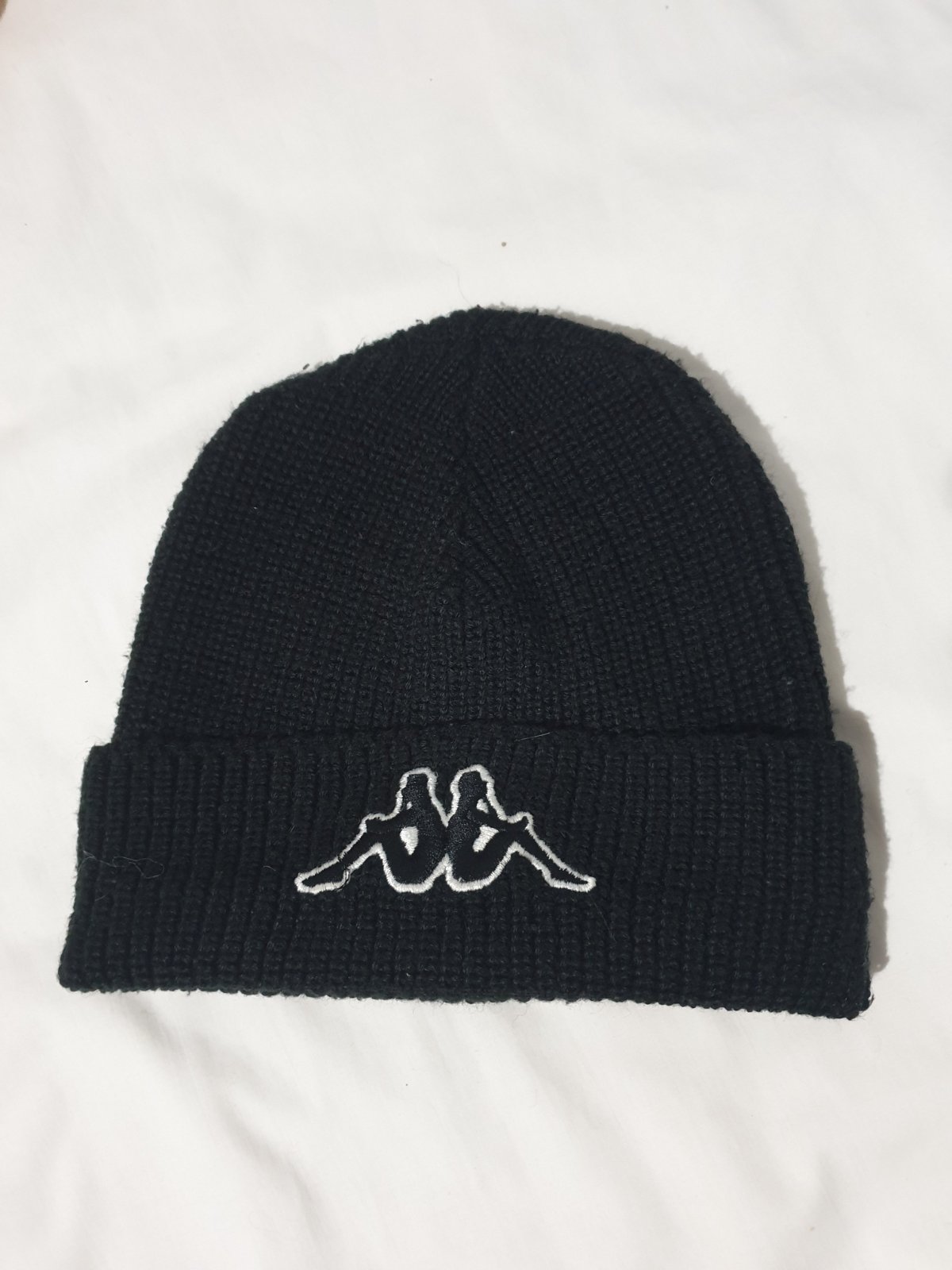 Un bonnet Kappa Hoppa noir en tricot avec le logo brodé sur le devant  