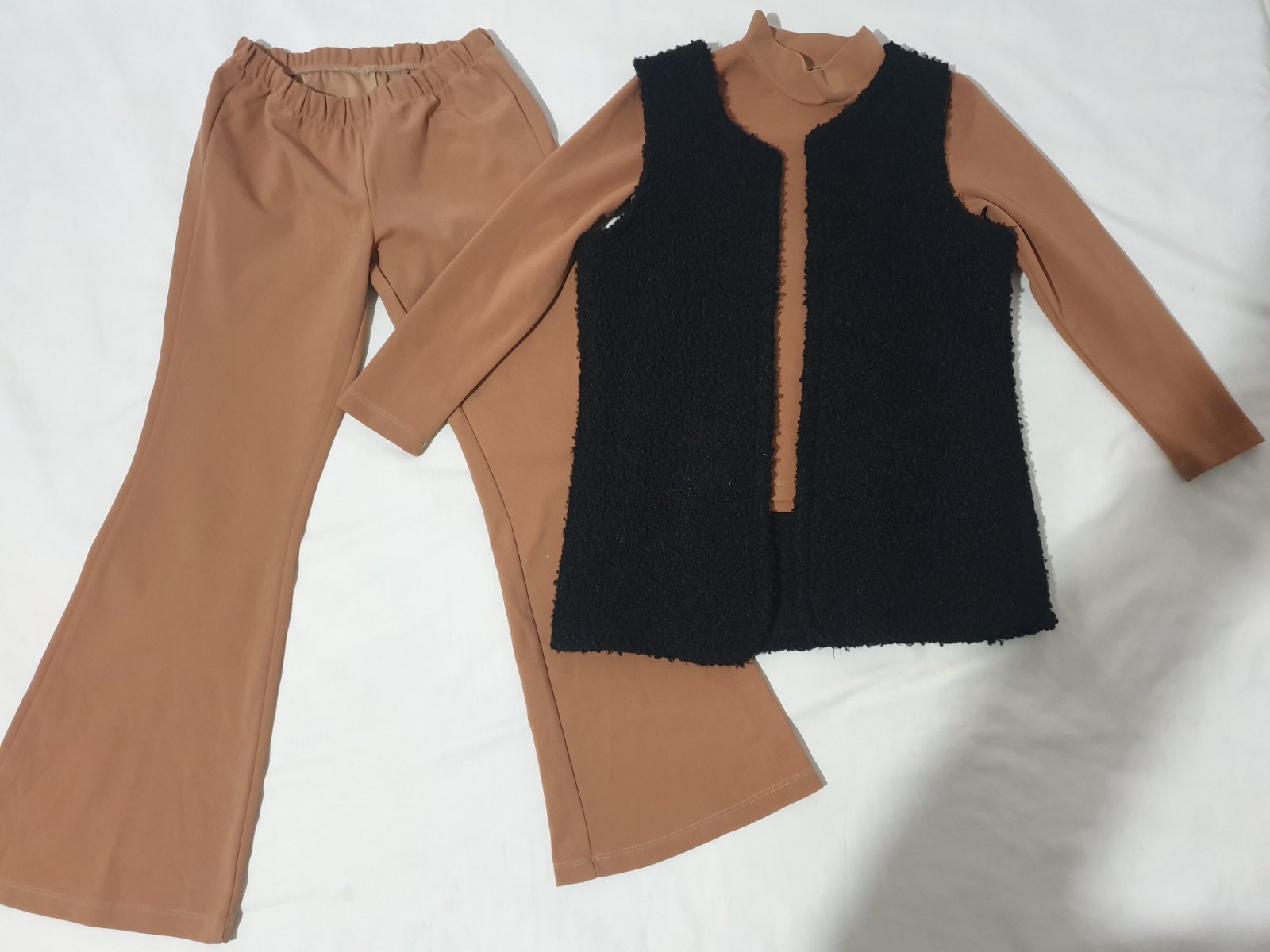 Ensemble se compose d'un pantalon et d'un pull à col roulé de couleur camel, superposé d'un gilet sans manches noir en fausse fourrure taille 10 ans