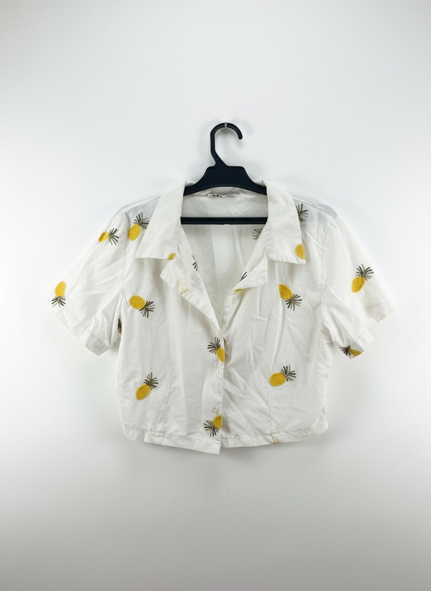 Chemise courte blanche avec des motifs d’ananas.