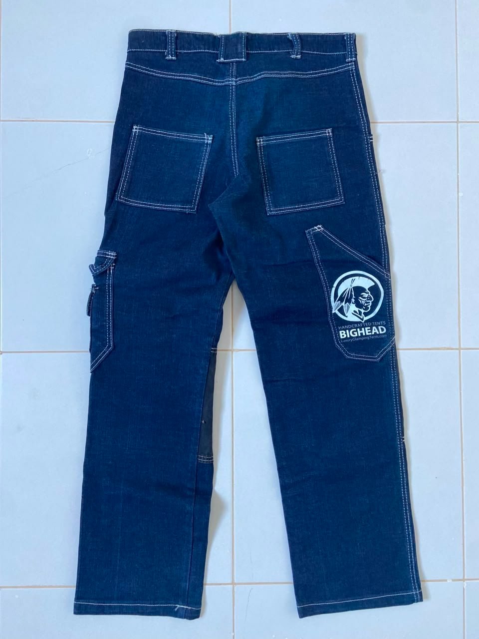 Jean de style charpentier (carpenter pants) arbore sur la poche arrière droite le logo officiel de la marque slovène BIGHEAD Glamping Solutions