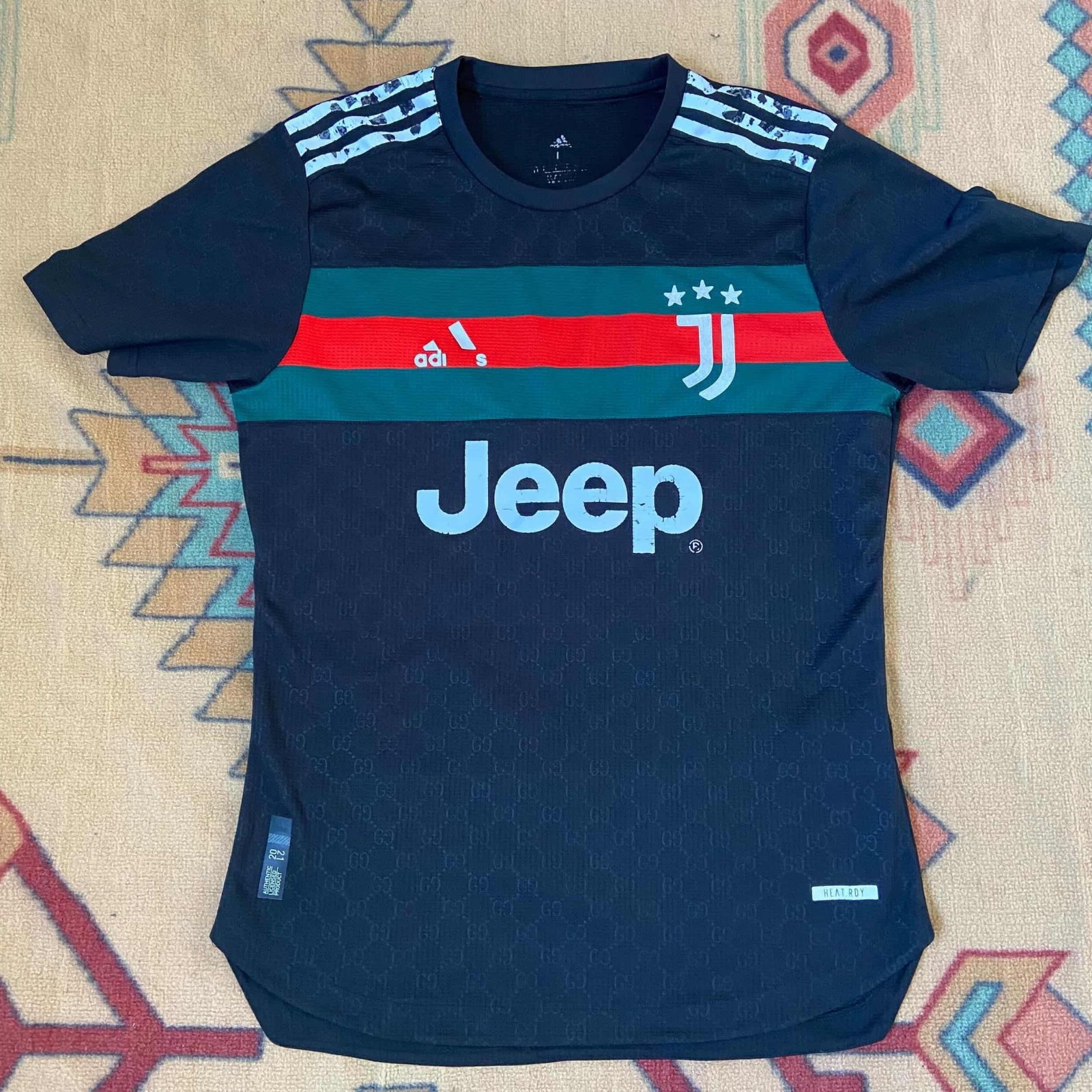 Maillot de football Juventus x Gucci noir arbore un motif monogramme subtil sur tout le corps et des détails rouges et verts sur la poitrine
